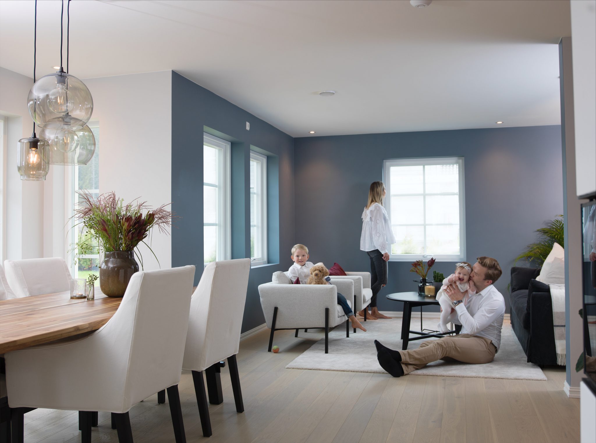 Familien samlet i den åpne stue- og kjøkkenløsningen i sitt ABChus